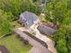 Aerial view of a large gray home with a landscaped yard and extended driveway surrounded by mature trees at 2555 Chattahoochee Ln, Cumming, GA 30041
