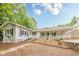 View of the back exterior featuring a long porch, white railings, and well-maintained landscaping at 2555 Chattahoochee Ln, Cumming, GA 30041