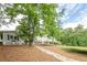 Backyard features a stone walkway leading to the main house and a detached building surrounded by lush greenery at 2555 Chattahoochee Ln, Cumming, GA 30041