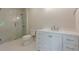 Modern bathroom featuring a glass enclosed shower and vanity with white cabinets and drawers and silver hardware at 2555 Chattahoochee Ln, Cumming, GA 30041