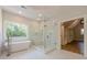 A luxurious bathroom featuring a soaking tub, walk-in shower, and marble flooring at 2555 Chattahoochee Ln, Cumming, GA 30041