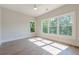 Well-lit bedroom with hardwood floors and three large windows showcasing the scenic views at 2555 Chattahoochee Ln, Cumming, GA 30041