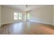 Bright bedroom with hardwood floors, ceiling fan, white trim, and abundant natural light at 2555 Chattahoochee Ln, Cumming, GA 30041