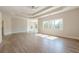Spacious primary bedroom with sitting area, tray ceilings, large windows and light hardwood flooring at 2555 Chattahoochee Ln, Cumming, GA 30041