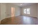 Neutral bedroom featuring hardwood floors, a ceiling fan, and ample natural light from the window at 2555 Chattahoochee Ln, Cumming, GA 30041