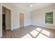 Serene bedroom featuring hardwood floors, ceiling fan, and a large window overlooking lush greenery at 2555 Chattahoochee Ln, Cumming, GA 30041