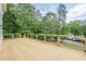 Wide wooden deck, surrounded by trees, offering a serene outdoor space for relaxation at 2555 Chattahoochee Ln, Cumming, GA 30041