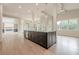 Large kitchen island with sink and dishwasher, hardwood floors, and view to dining area with fireplace at 2555 Chattahoochee Ln, Cumming, GA 30041