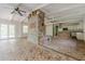 Open-concept living space with brick fireplace, hardwood floors, exposed beams and an attached partial kitchen area at 2555 Chattahoochee Ln, Cumming, GA 30041