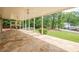 Covered stone patio provides ample space for outdoor seating with backyard views and access to an upper deck at 2555 Chattahoochee Ln, Cumming, GA 30041