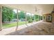 Covered patio with stone flooring, ceiling fans, and views of the expansive backyard and surrounding greenery at 2555 Chattahoochee Ln, Cumming, GA 30041