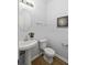 Half bathroom with a pedestal sink, decorative mirror, and hardwood floors at 4457 Watson Ridge Dr, Stone Mountain, GA 30083