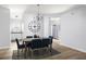 Modern dining space features a dark table with blue chairs, art, and a view into the kitchen at 4457 Watson Ridge Dr, Stone Mountain, GA 30083