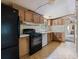 Kitchen with wood cabinets, black appliances, and linoleum floors at 4934 Pickys Se Holw, Acworth, GA 30102
