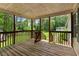 Covered porch with wooden floors and railings, overlooking a green yard at 4934 Pickys Se Holw, Acworth, GA 30102