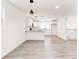 Bright, open-concept kitchen with gray countertops, modern fixtures, white cabinets and wood-look floors at 809 Vinton Wood Rd, Forest Park, GA 30297