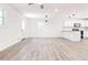 Bright open floor plan featuring a modern kitchen, white cabinets, wood-look floors, and updated lighting at 809 Vinton Wood Rd, Forest Park, GA 30297