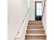 Carpeted stairs leading to an upper level, accented with light wood handrail and dark door at 809 Vinton Wood Rd, Forest Park, GA 30297