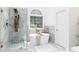 Modern bathroom with freestanding tub, stylish shower, and mosaic tile accents by arched window at 823 Laurel Crest Sw Ct, Marietta, GA 30064