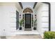 Elegant entryway with black door, white brick, and arched window detail with modern sconces at 823 Laurel Crest Sw Ct, Marietta, GA 30064