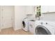 Well-lit laundry room with front-loading washer and dryer and custom cabinetry at 823 Laurel Crest Sw Ct, Marietta, GA 30064