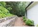White brick home featuring a stone retaining wall with lush landscaping along a pebble walkway at 823 Laurel Crest Sw Ct, Marietta, GA 30064