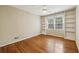 Bedroom features hardwood floors, a ceiling fan, and built-in bookshelves surrounding a window at 95 Brandon Ridge Dr, Atlanta, GA 30328