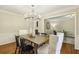 Bright dining room with hardwood floors, modern chandelier, seating for six, and a view to the study at 95 Brandon Ridge Dr, Atlanta, GA 30328
