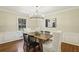 Elegant dining room with modern chandelier, hardwood floors, wainscoting, a large window, and seating for six at 95 Brandon Ridge Dr, Atlanta, GA 30328