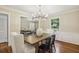 Well-lit dining room featuring hardwood floors, seating for six, with views into the office and kitchen at 95 Brandon Ridge Dr, Atlanta, GA 30328