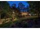 Brick home illuminated at dusk with dormer windows, landscaped yard, and brick walkway at 95 Brandon Ridge Dr, Atlanta, GA 30328