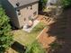 Aerial view of a backyard features a patio dining area, a lawn, and a wooded area at 1749 Grand Oaks Dr, Woodstock, GA 30188