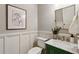 Stylish half bathroom with marble countertops, green cabinetry, and elegant fixtures at 1749 Grand Oaks Dr, Woodstock, GA 30188