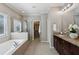 A luxurious bathroom features granite double sinks, soaking tub, glass shower, and walk-in closet at 1749 Grand Oaks Dr, Woodstock, GA 30188