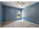 This bedroom features a ceiling fan, a window letting in natural light, and neutral carpeting at 1749 Grand Oaks Dr, Woodstock, GA 30188