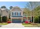 Charming two-story home with a brick facade, gray trim, blue shutters and a well-maintained lawn at 1749 Grand Oaks Dr, Woodstock, GA 30188