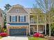Charming two-story home with a brick-and-siding exterior, front porch swing and manicured lawn at 1749 Grand Oaks Dr, Woodstock, GA 30188