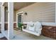 Cozy front porch with a swing, brick accents and neutral-colored siding at 1749 Grand Oaks Dr, Woodstock, GA 30188