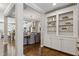 View of hallway leading to the open concept dining and kitchen space, with built-in bookshelves at 1749 Grand Oaks Dr, Woodstock, GA 30188