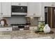 Contemporary kitchen features stainless steel appliances, granite countertops, and tile backsplash at 1749 Grand Oaks Dr, Woodstock, GA 30188