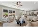 Bright living room features large windows, a ceiling fan, and an open floor plan to the kitchen at 1749 Grand Oaks Dr, Woodstock, GA 30188