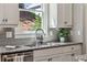 Close up view of the kitchen sink, faucet and countertops. A window provides natural lighting at 1749 Grand Oaks Dr, Woodstock, GA 30188