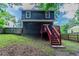 Exterior with a dark blue siding, red stairs and a grassy yard at 233 Clayton St, Fairburn, GA 30213