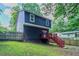 Exterior with a dark blue siding, red stairs and a grassy yard at 233 Clayton St, Fairburn, GA 30213