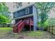 The dark blue home is surrounded by a well-manicured lawn, and a wood fence at 233 Clayton St, Fairburn, GA 30213