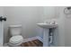 Powder room features a pedestal sink, modern fixtures, and wood-look flooring at 233 Clayton St, Fairburn, GA 30213