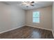 Bedroom features wood-look flooring, a window, and a ceiling fan at 233 Clayton St, Fairburn, GA 30213