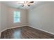 Bright bedroom features wood-look flooring, a window, and a ceiling fan at 233 Clayton St, Fairburn, GA 30213