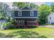 Charming two-story home featuring a cozy front porch and a well-manicured lawn at 233 Clayton St, Fairburn, GA 30213