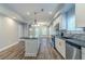 Open concept kitchen with granite countertops, stainless appliances, and wood flooring at 233 Clayton St, Fairburn, GA 30213